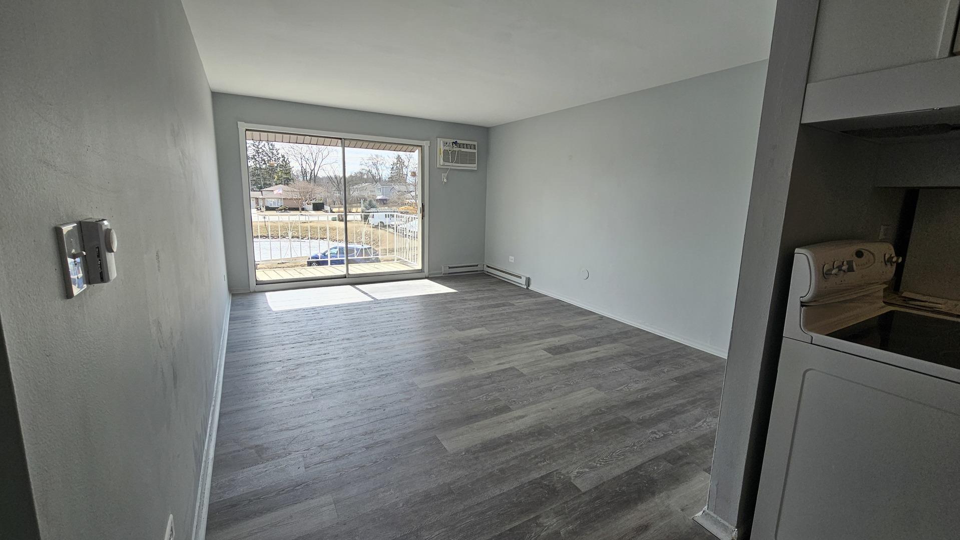 850 East Old Willow Road, Unit 218 Prospect Heights, IL 60070 - Photo 3 of 6 a view of an empty room with wooden floor and a window
