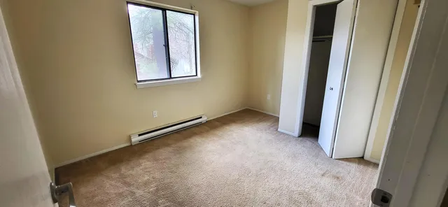 an empty room with windows and closet