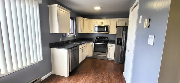 a kitchen with stainless steel appliances a stove top oven a sink and a refrigerator