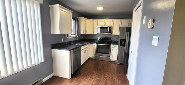 a kitchen with stainless steel appliances a stove top oven a sink and a refrigerator