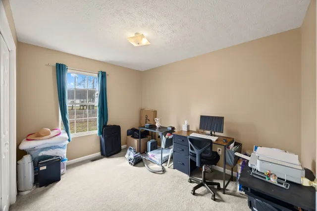 a view of a workspace with furniture and a window