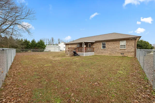 a view of a house with backyard and trees