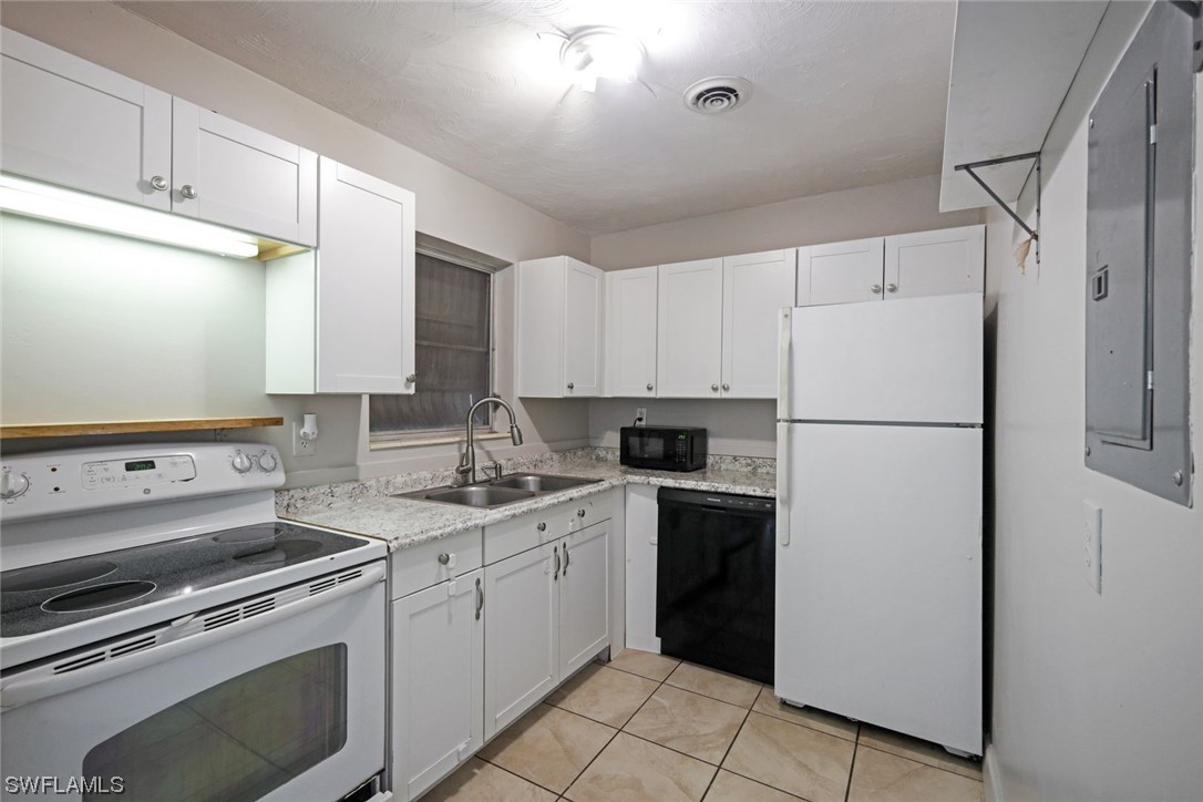 2968 Sunset Road Fort Myers, FL 33901 - Photo 6 of 23 a kitchen with a refrigerator sink stove and cabinets