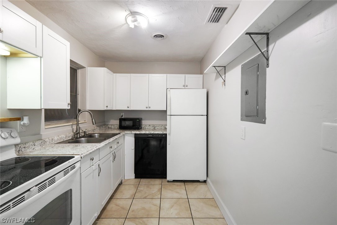 2968 Sunset Road Fort Myers, FL 33901 - Photo 7 of 23 a kitchen with a sink a refrigerator a stove top oven and cabinets