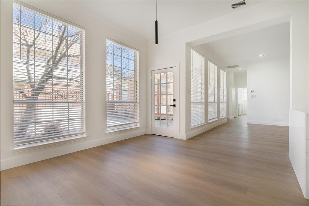 7524 Aberdon Road Dallas, TX 75252 - Photo 14 of 39 Unfurnished dining area with ornamental molding, visible vents, baseboards, and wood finished floors