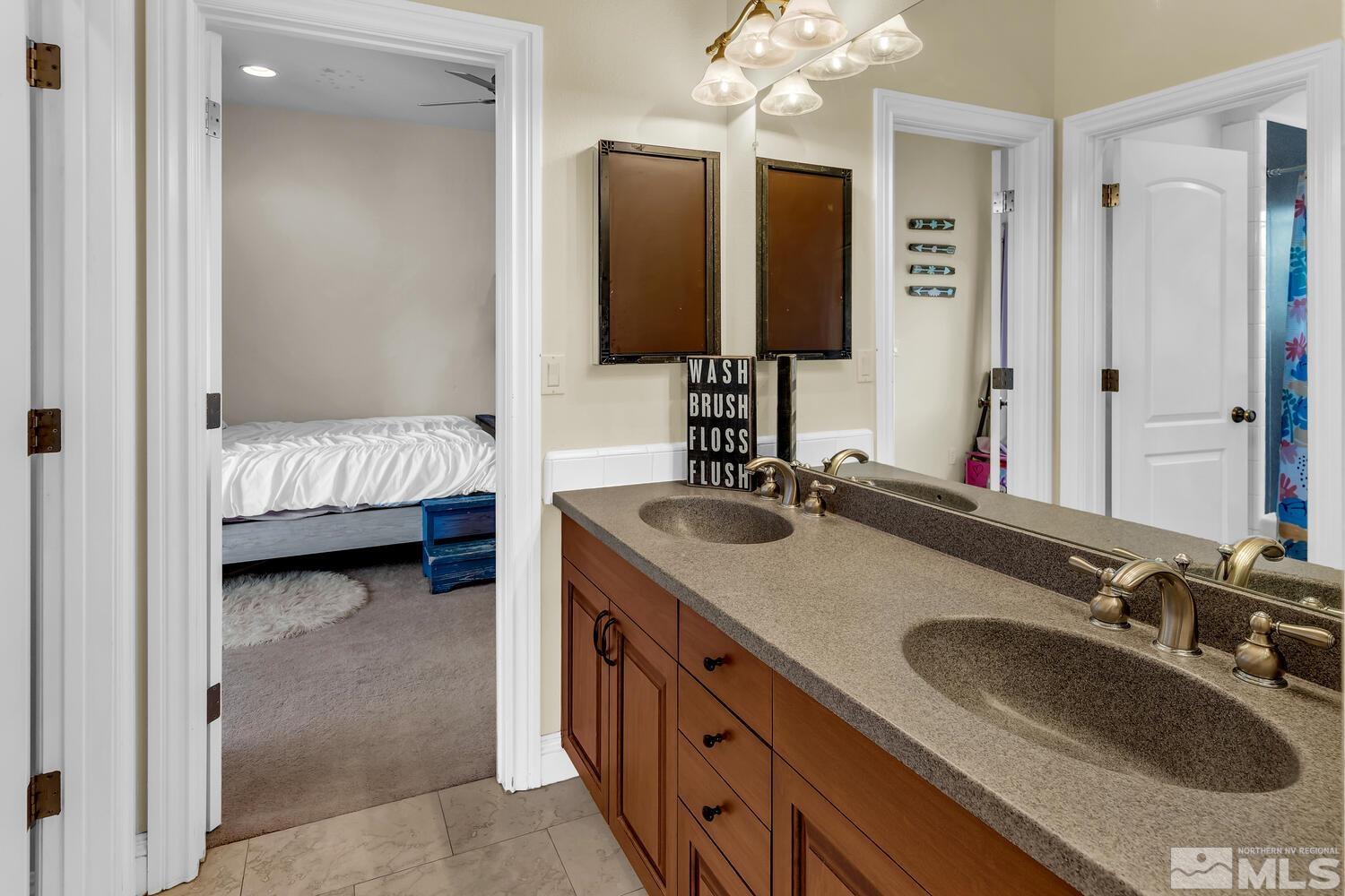 3100 Yellow Tail Road Reno, NV 89510 - Photo 15 of 40 a en suite bathroom with a double vanity sink and a mirror