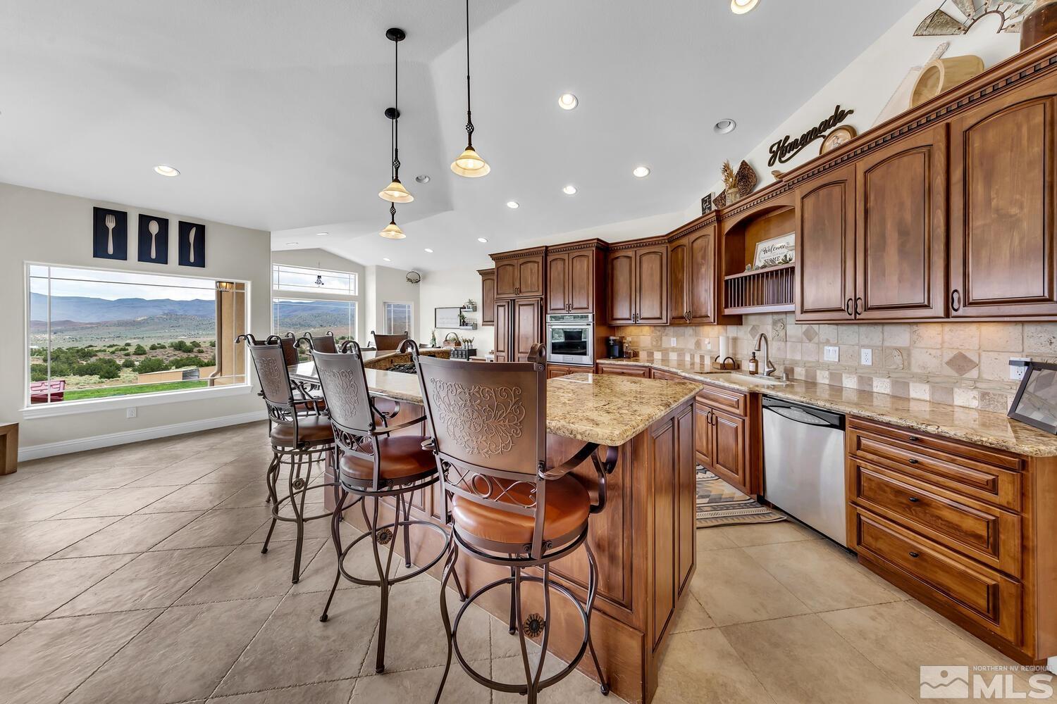3100 Yellow Tail Road Reno, NV 89510 - Photo 5 of 40 a kitchen with stainless steel appliances granite countertop a table chairs sink and cabinets