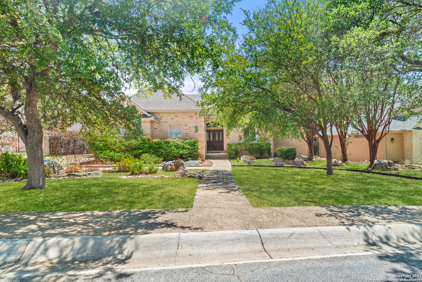 20922 Cactus Loop San Antonio, TX 78258 - Photo 1 of 1 a front view of a house with a garden and trees