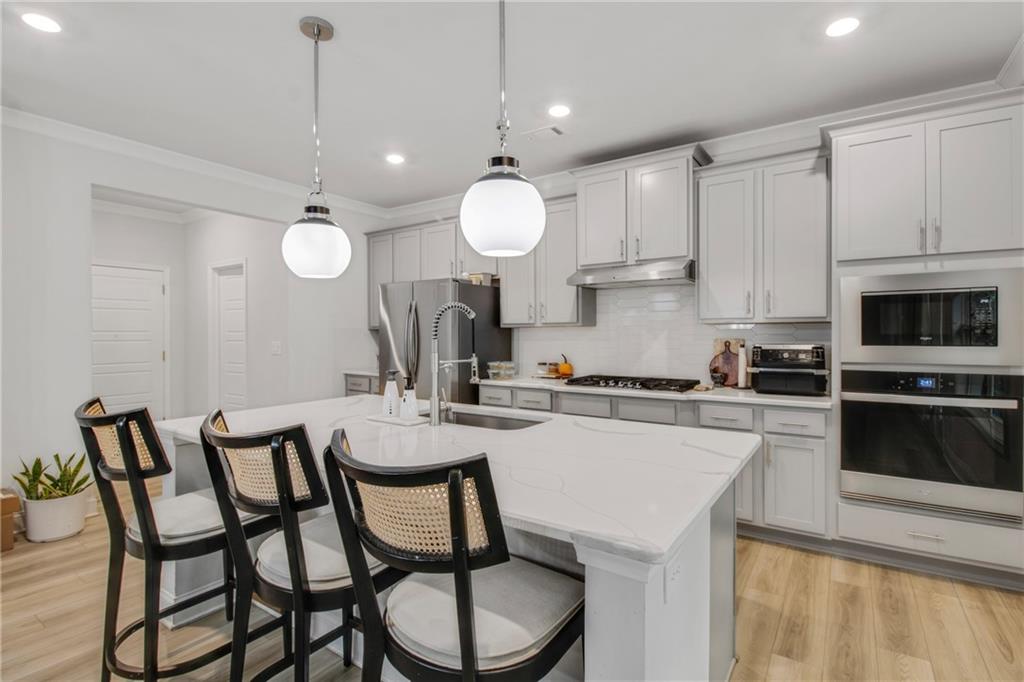 338 Ryston Way Grayson, GA 30017 - Photo 18 of 61 a kitchen with a dining table chairs and white cabinets