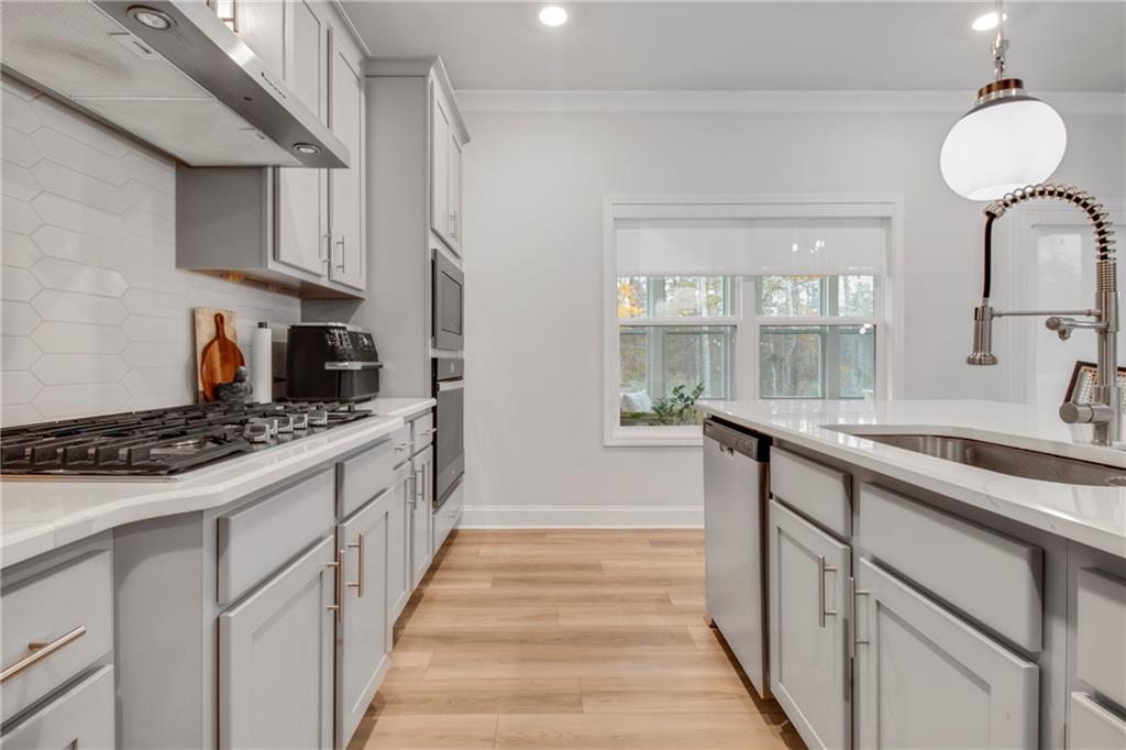 338 Ryston Way Grayson, GA 30017 - Photo 21 of 61 a kitchen with stainless steel appliances a sink stove and cabinets