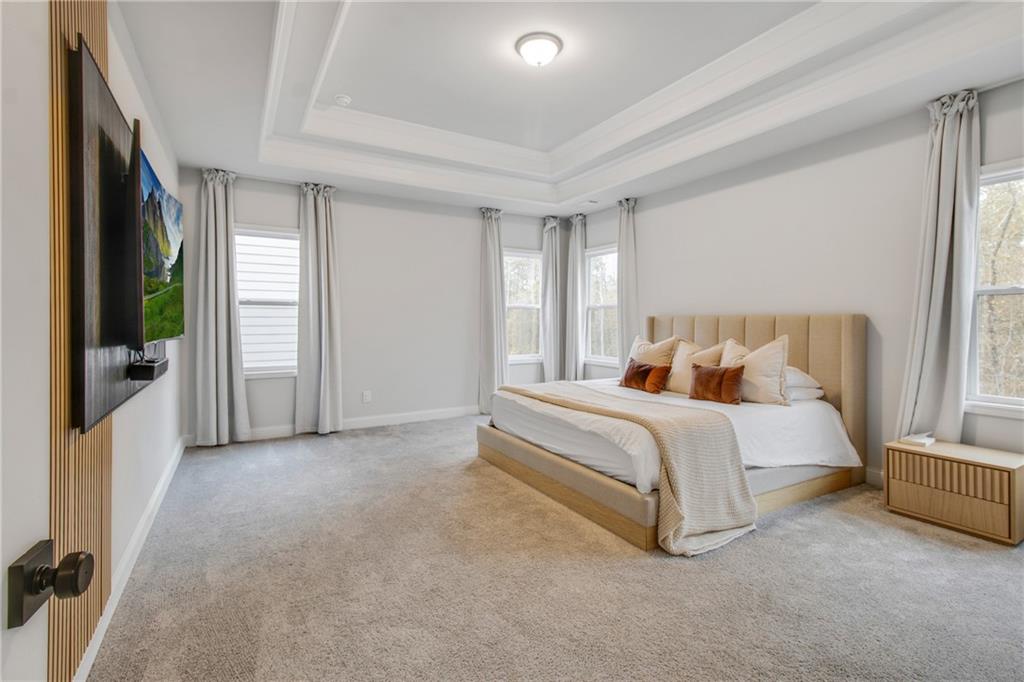 338 Ryston Way Grayson, GA 30017 - Photo 23 of 61 a spacious bedroom with a bed and a large window