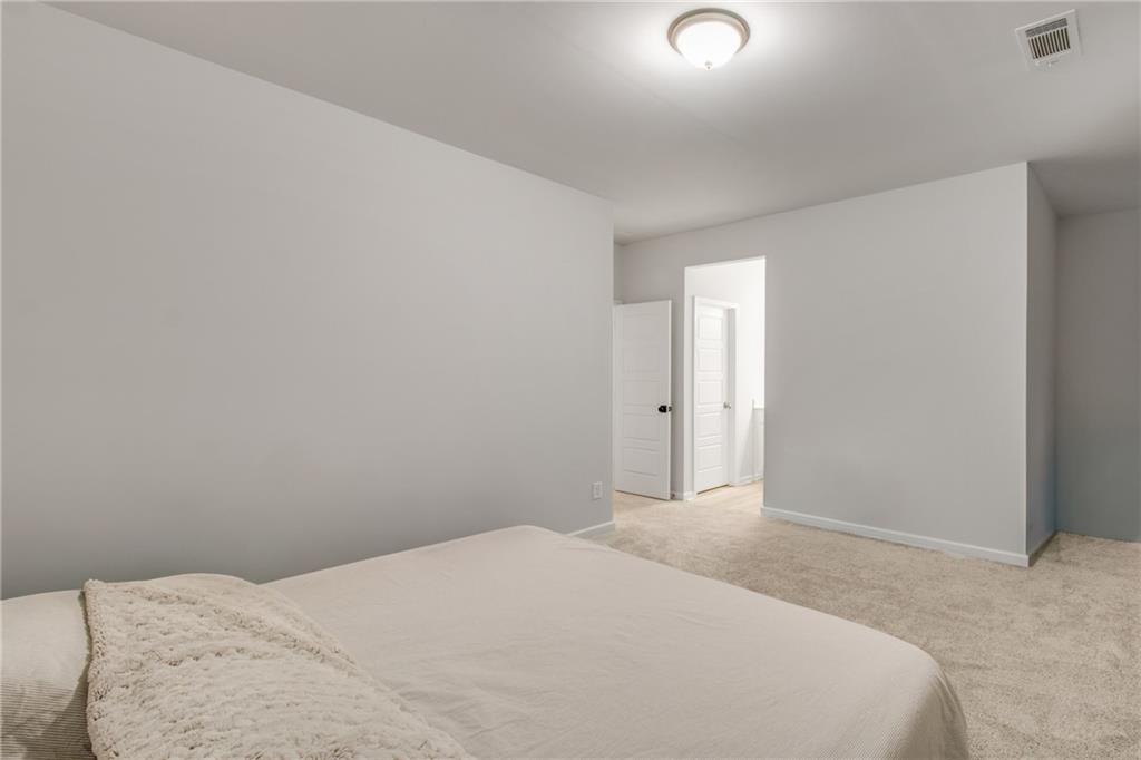 338 Ryston Way Grayson, GA 30017 - Photo 41 of 61 a bedroom with a bed and a night stand