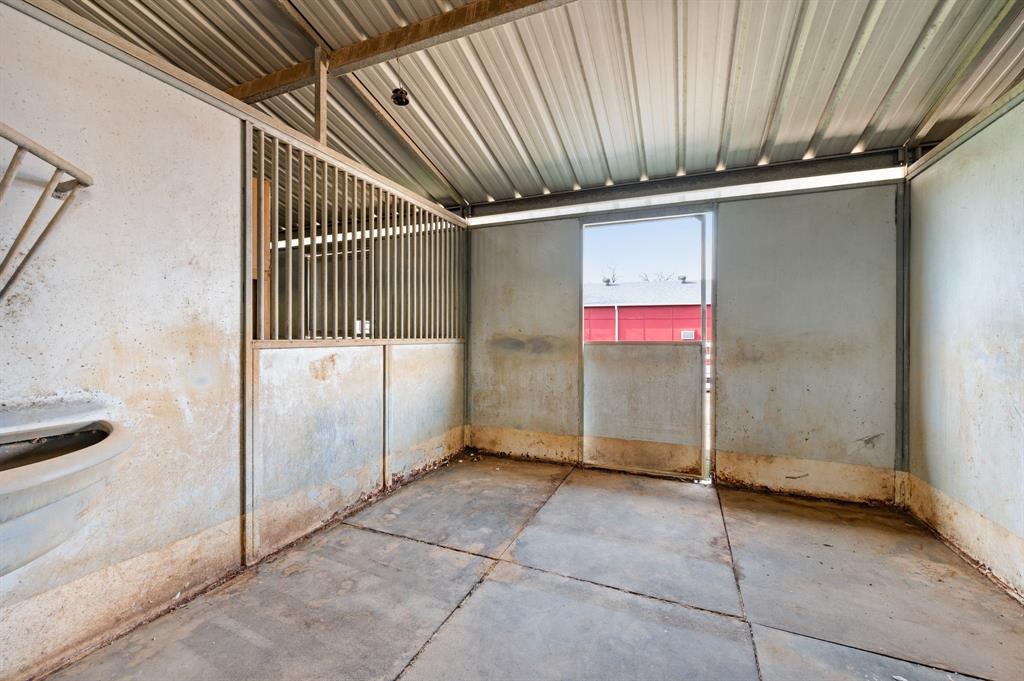 7260 Hudson Cemetery Road Mansfield, TX 76063 - Photo 6 of 40 Stall featuring a metal grate upper wall, concrete floor, and corrugated metal roof