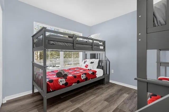 a bedroom with a bed and wooden floor