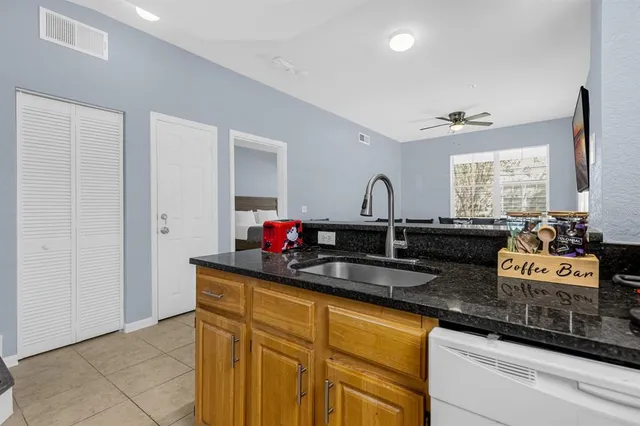 a kitchen with granite countertop a sink and cabinets