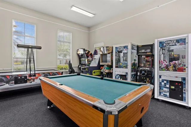 a room with pool table two windows and a flat screen tv