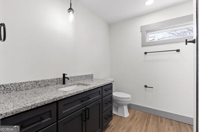 a bathroom with a granite countertop sink and a bathtub