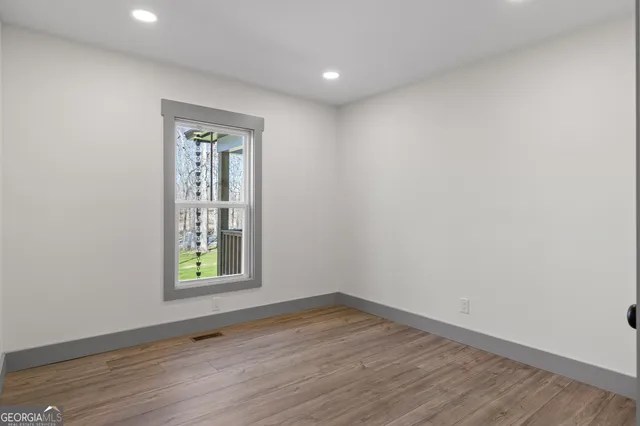 a view of a hallway with wooden floor and entryway
