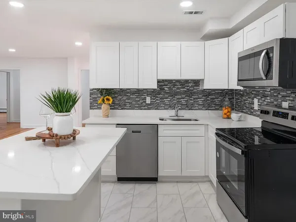 a kitchen with stainless steel appliances a stove a sink and a microwave