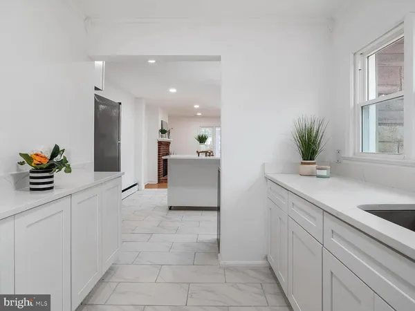 a kitchen with stainless steel appliances kitchen island granite countertop a sink and a white cabinets