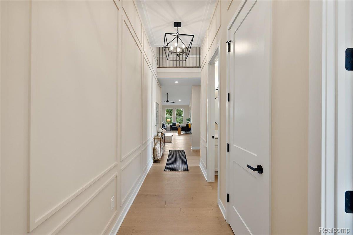 2032 Breckenridge Court, Unit 9 Rochester, MI 48309 - Photo 8 of 39 Corridor featuring light wood-style flooring, a decorative wall, and a chandelier