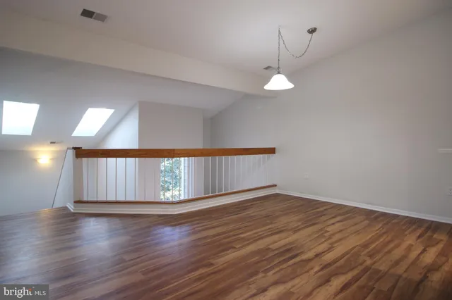 a view of empty room with wooden floor