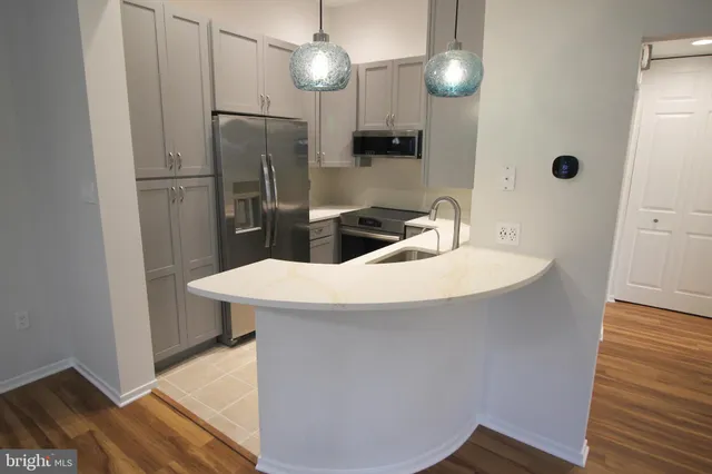 a kitchen with stainless steel appliances granite countertop a sink a stove and a refrigerator