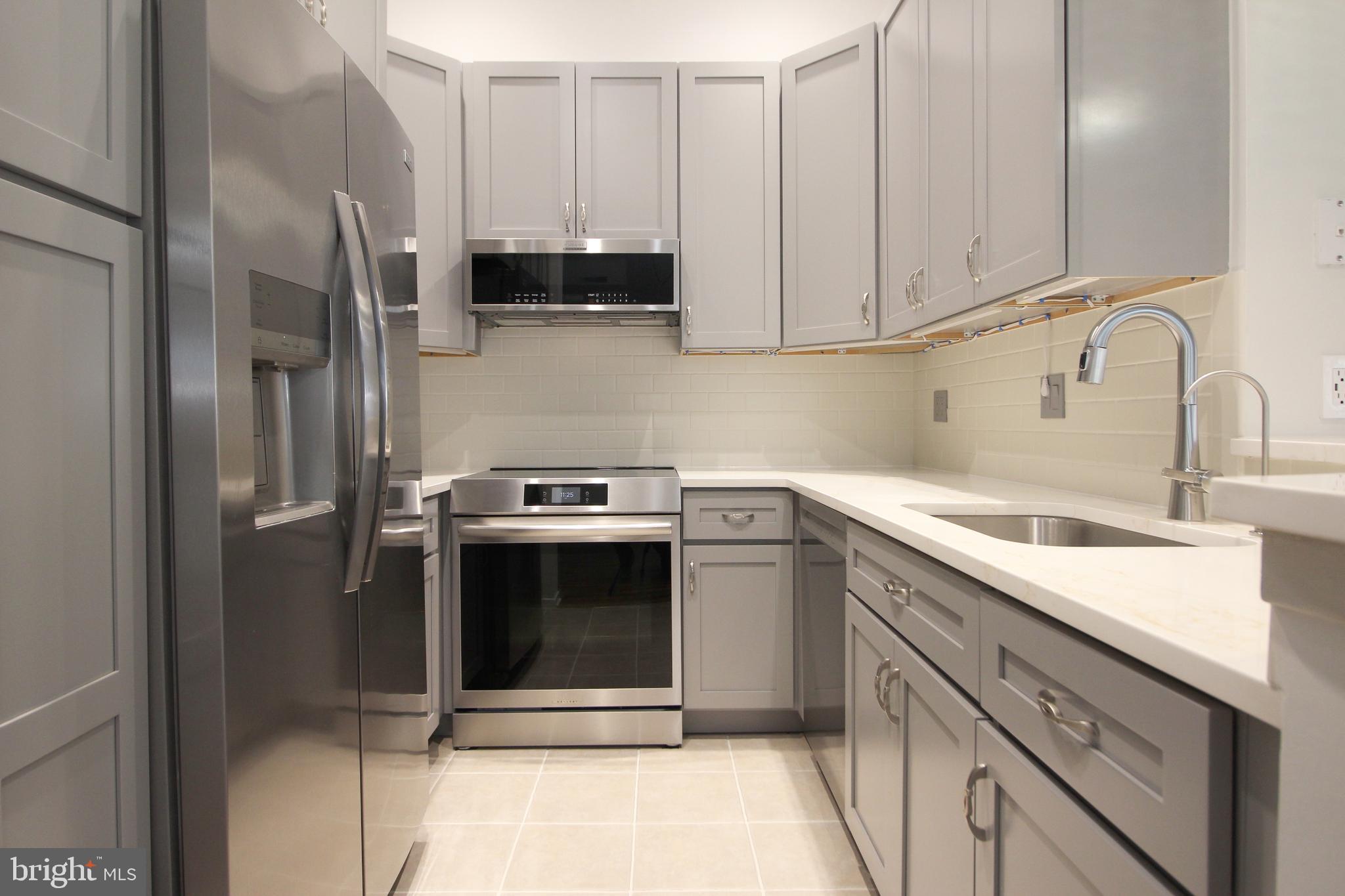 1956A Villaridge Drive, Unit 1956B Reston, VA 20191 - Photo 17 of 24 a kitchen with stainless steel appliances granite countertop a sink a stove and a refrigerator
