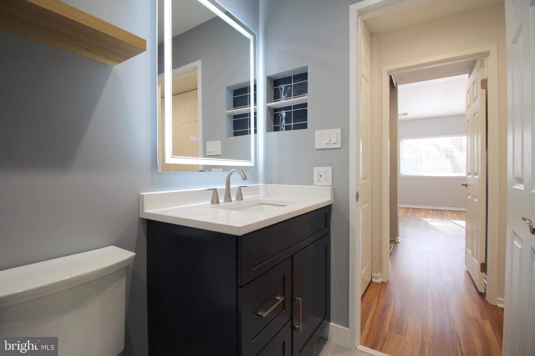 1956A Villaridge Drive, Unit 1956B Reston, VA 20191 - Photo 21 of 24 a bathroom with a sink a mirror and a toilet