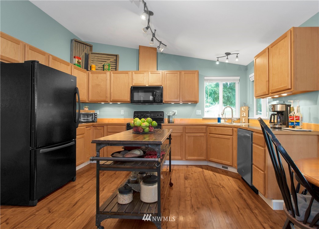 8801 178th Avenue Southwest Rochester, WA 98579 - Photo 14 of 39 a kitchen with stainless steel appliances a refrigerator a sink a stove a table and chairs