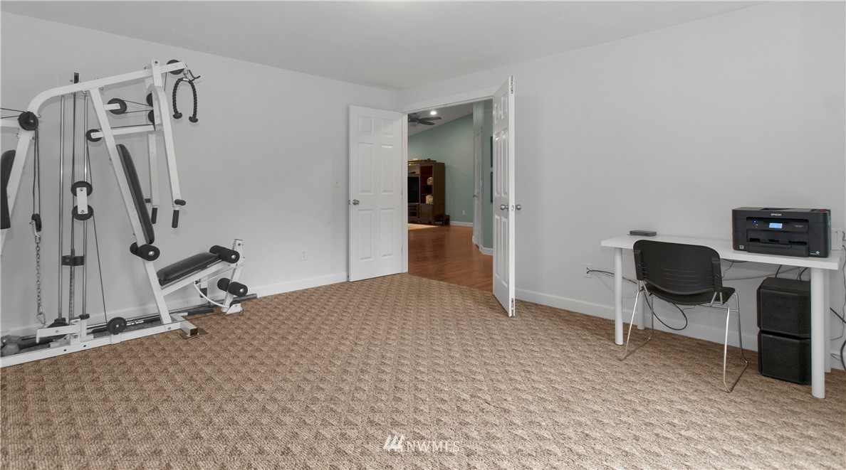 8801 178th Avenue Southwest Rochester, WA 98579 - Photo 4 of 39 a bedroom with a chair and gym equipment