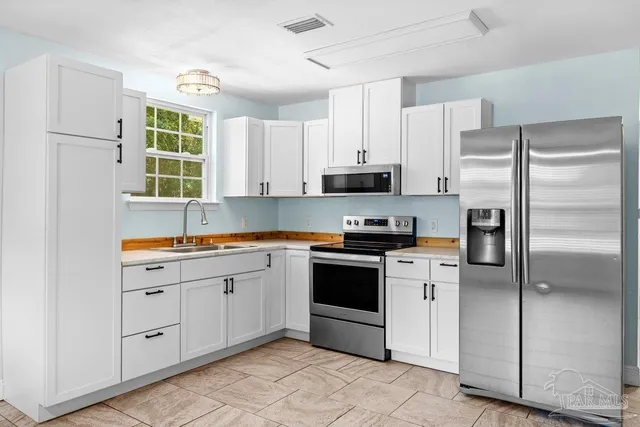 a kitchen with stainless steel appliances cabinets a sink and a window