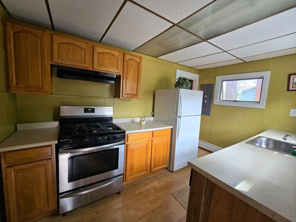 43 Shore Avenue Wareham, MA 02571 - Photo 9 of 32 a kitchen with stainless steel appliances granite countertop a stove a refrigerator and a microwave