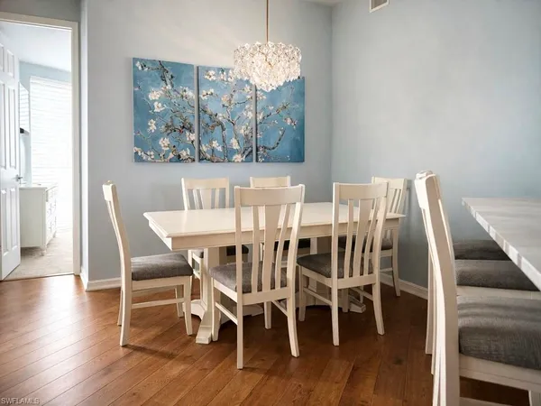 a view of a dining room with furniture wooden floor and chandelier