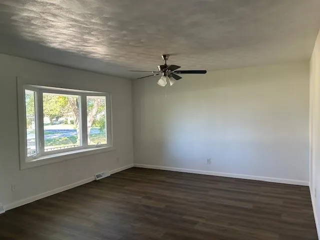 a view of a room with wooden floor and fan