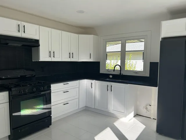 a kitchen with cabinets appliances and a window