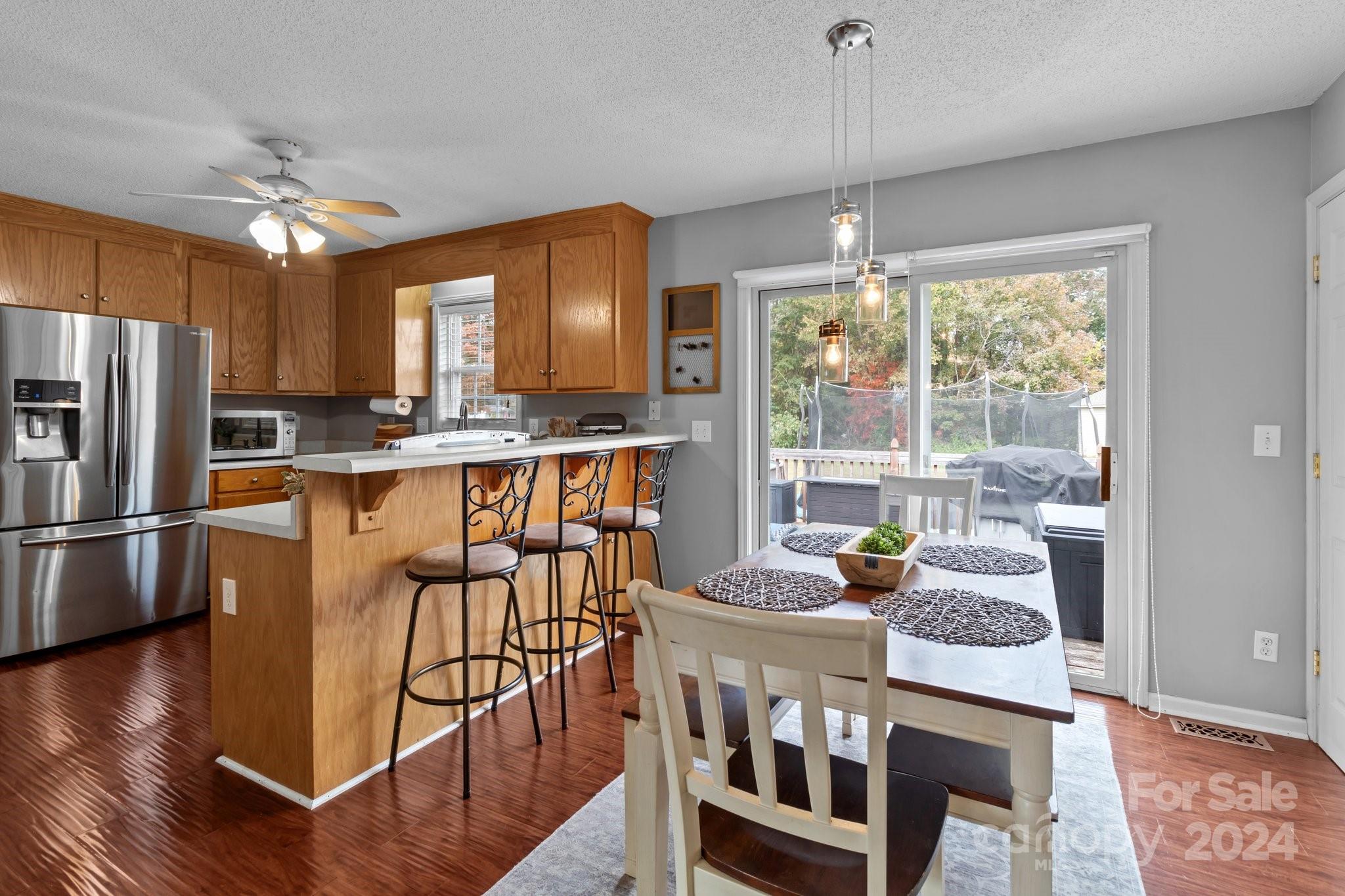 747 Sides Road Salisbury, NC 28146 - Photo 8 of 21 a kitchen with stainless steel appliances granite countertop a stove top oven a refrigerator a dining table and chairs with wooden floor