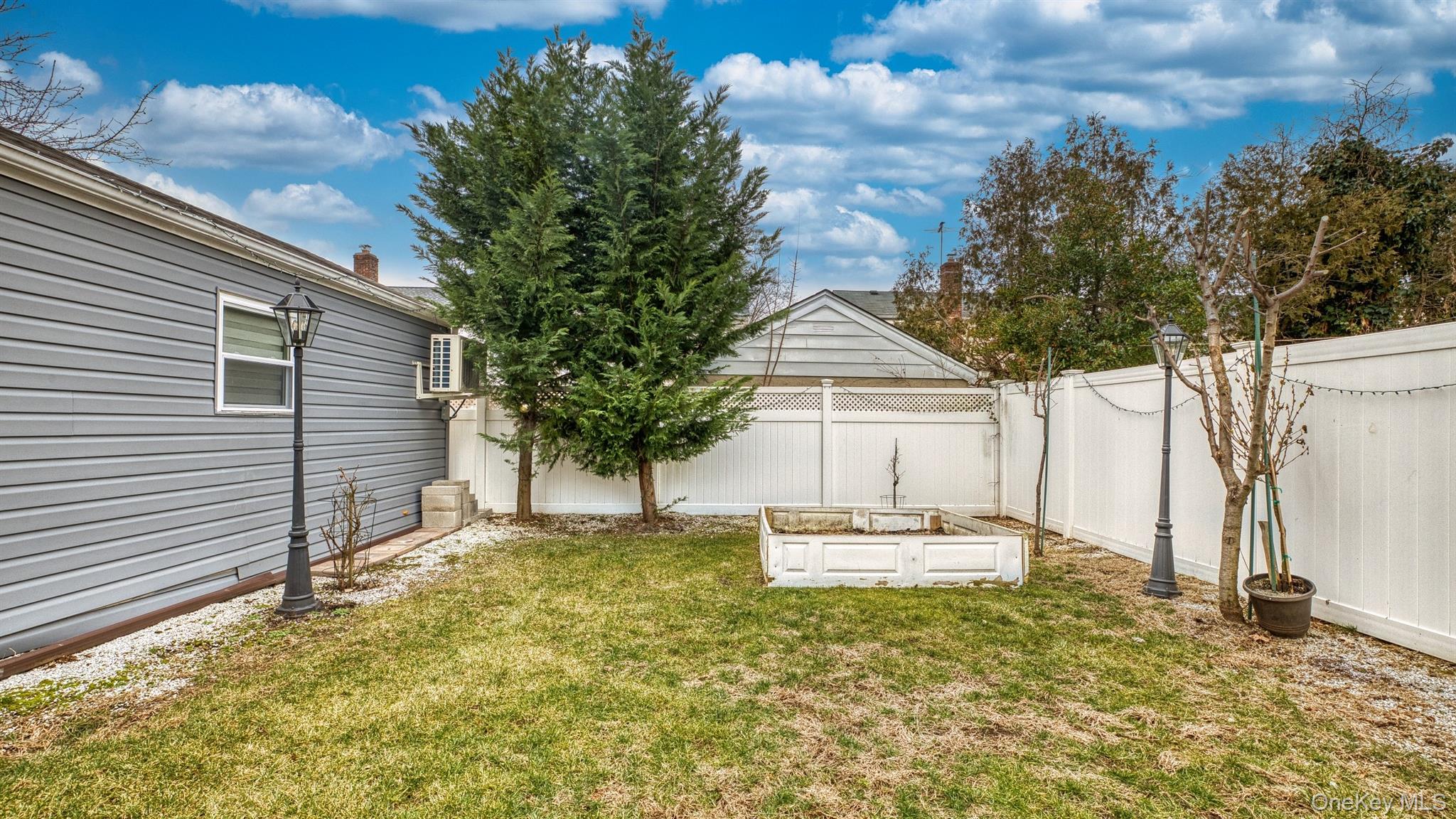 383 White Road Mineola, NY 11501 - Photo 20 of 21 a house with trees in front of it