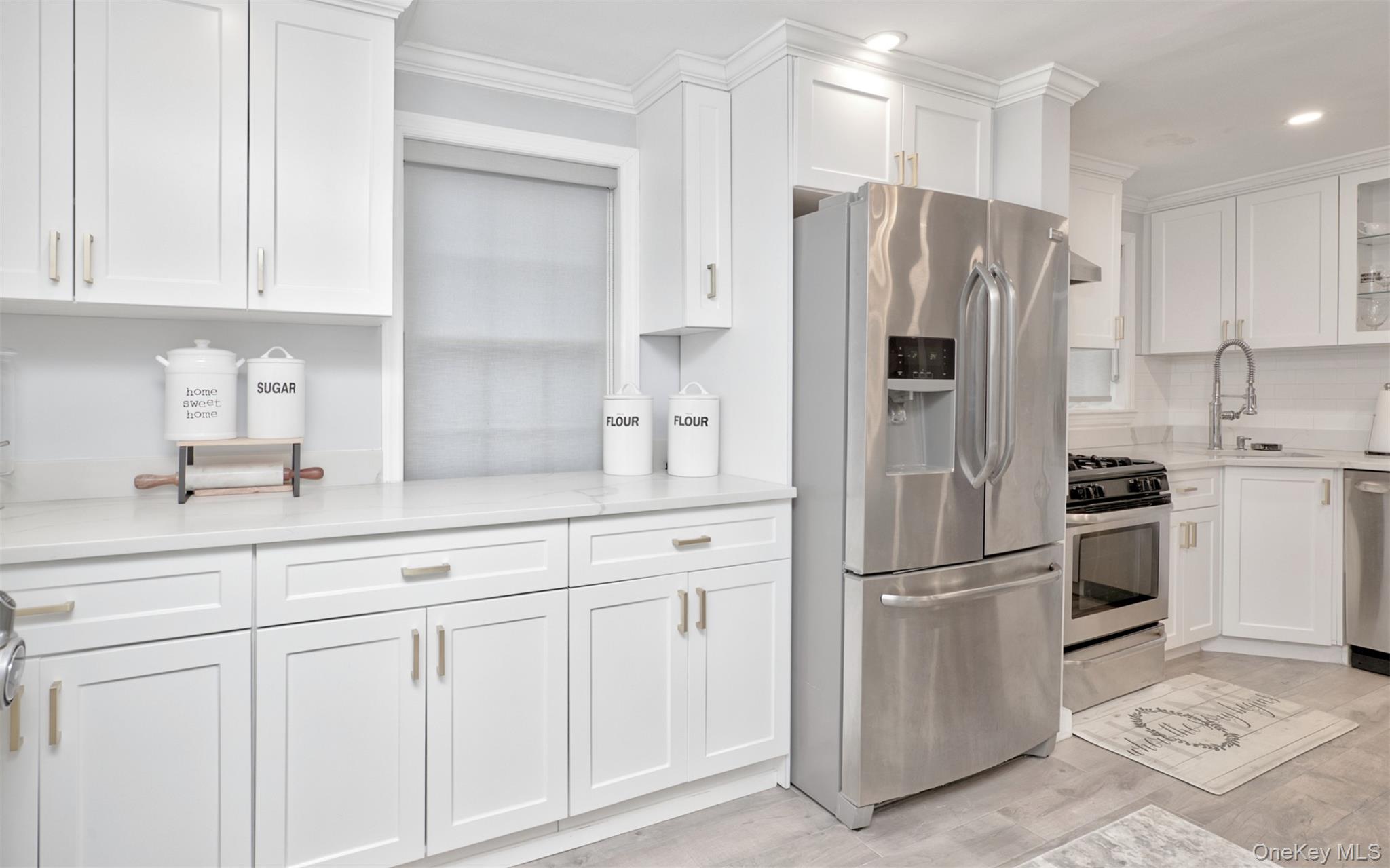 383 White Road Mineola, NY 11501 - Photo 5 of 21 a kitchen with white cabinets and stainless steel appliances