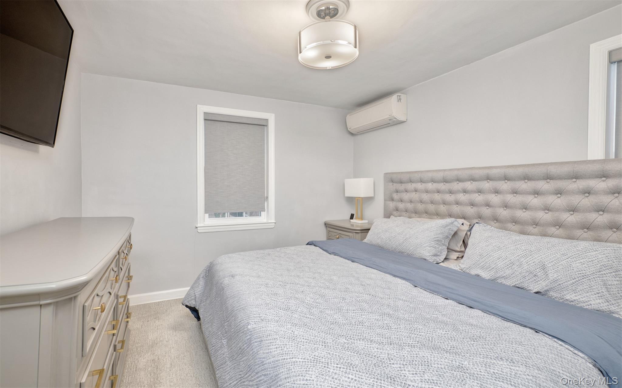 383 White Road Mineola, NY 11501 - Photo 10 of 21 a bedroom with a bed and a flat screen tv