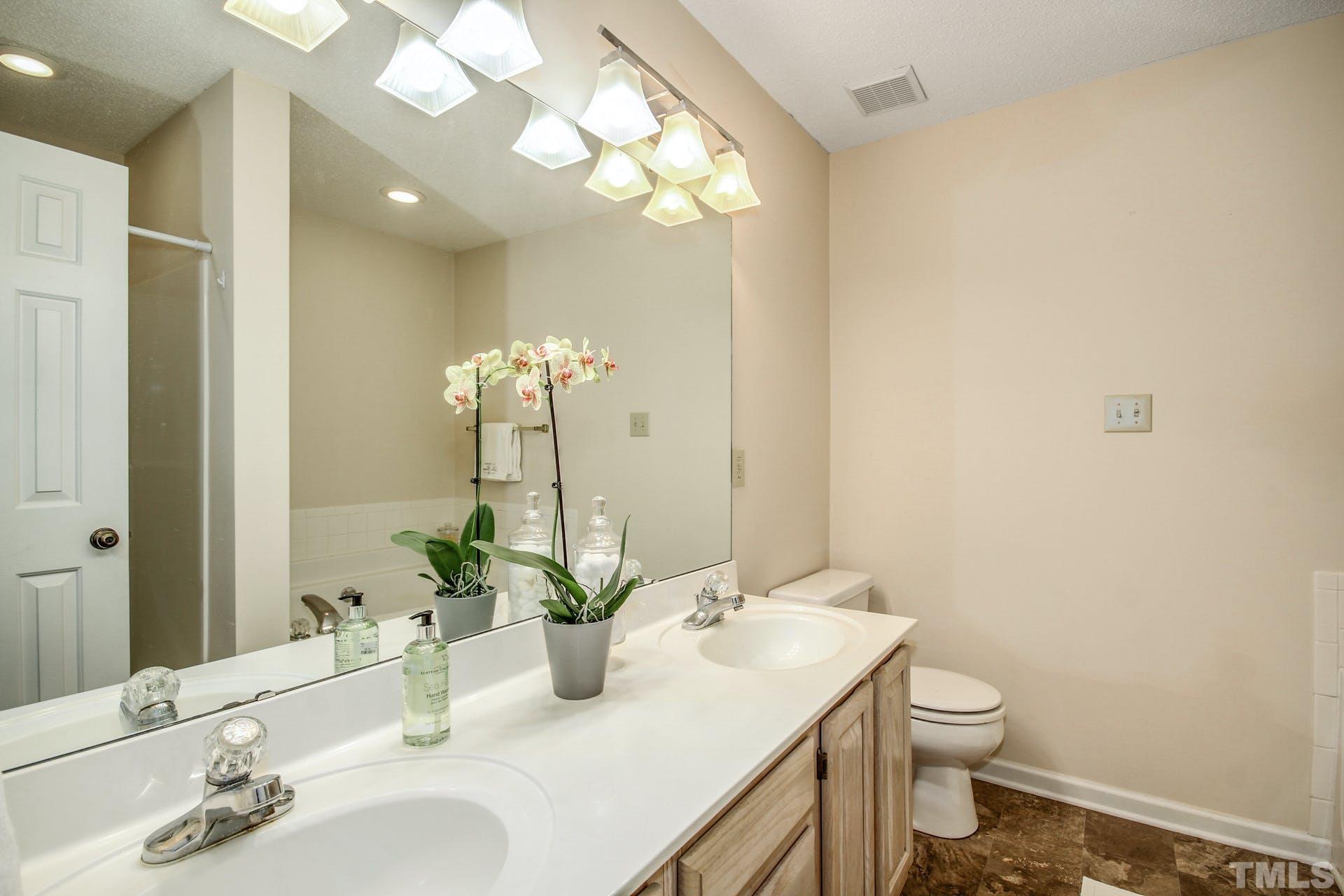 4460 Still Pines Drive Raleigh, NC 27613 - Photo 9 of 14 a bathroom with a sink and a mirror with toilet