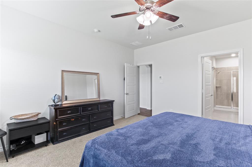 2920 Pinecrest Drive Aubrey, TX 76227 - Photo 20 of 27 a bedroom with a dresser and a chandelier