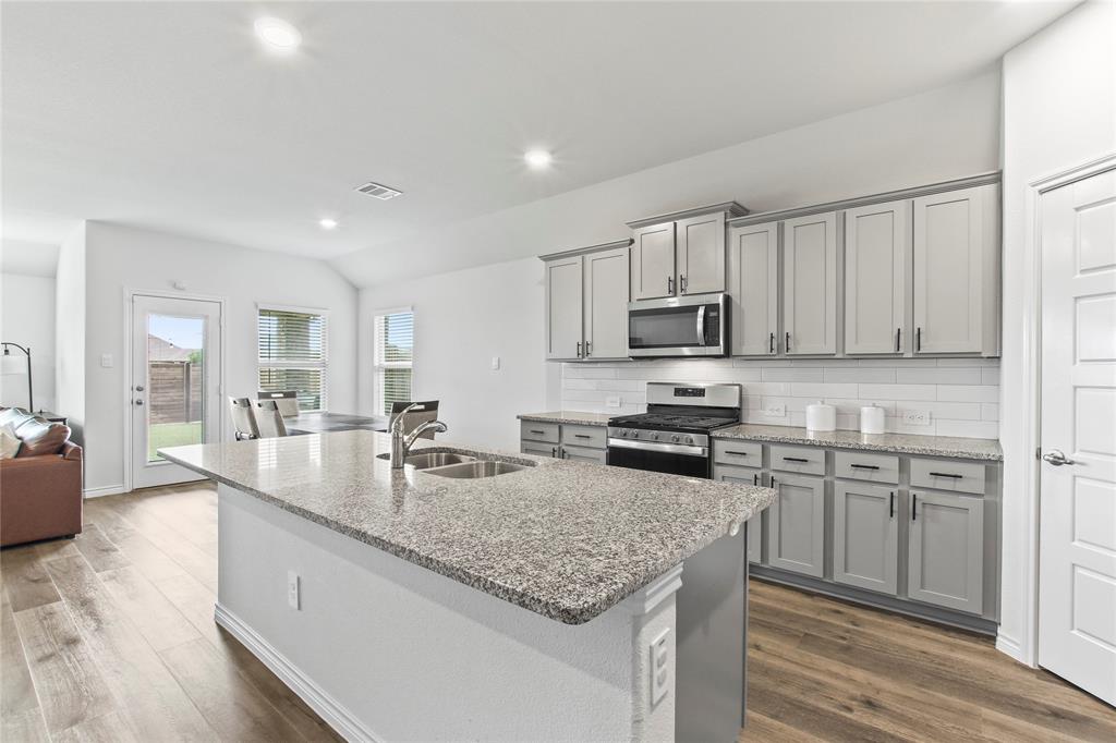 2920 Pinecrest Drive Aubrey, TX 76227 - Photo 5 of 27 a kitchen with stainless steel appliances granite countertop a sink dishwasher stove and refrigerator