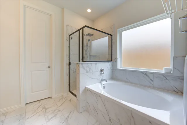 a bathroom with a tub sink and mirror