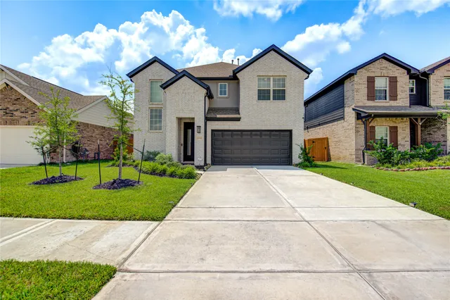 a front view of a house with a yard and garage