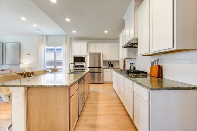 a large kitchen with stainless steel appliances lots of counter top space