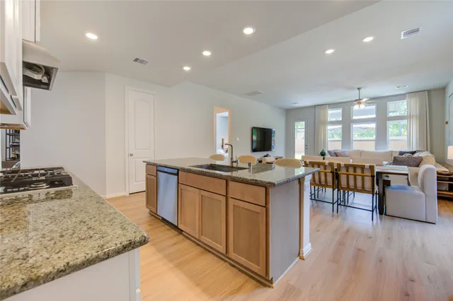 a large kitchen with granite countertop lots of counter space a sink and appliances