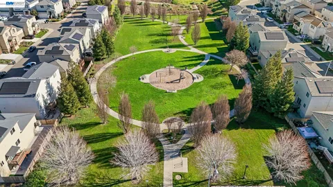 an aerial view of a residential houses with outdoor space and street view