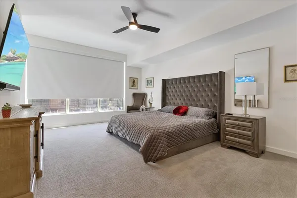 a spacious bedroom with a large bed and a chandelier