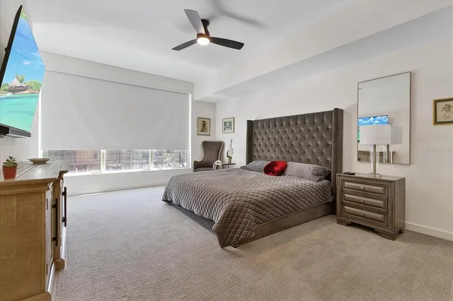 a spacious bedroom with a large bed and a chandelier